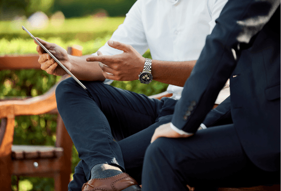 business people outside, discussing something on a tablet